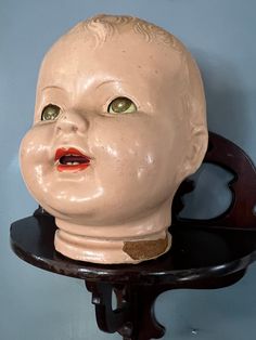 a ceramic head sitting on top of a wooden shelf