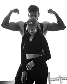 a man and woman flexing their muscles in black and white