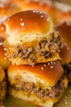 three hamburger sliders stacked on top of each other with cheese and meat toppings