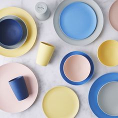 various colored plates and cups on a table