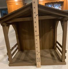 a wooden dollhouse with a measuring tape on the bottom and inside it's sides