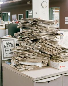 a stack of papers sitting on top of a filing cabinet