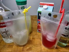 two plastic cups filled with drinks on top of a wooden table