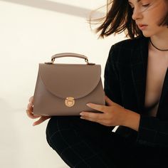 In a world of constantly changing trends and fashion, the "Taistra" messenger bag for women always remains a faithful symbol of your elegance and taste. Dimensions: 9,1х5,5х3,2 in / 23x14x8 cm. Material: genuine leather. Colors: black, brown (tobacco), gray (French grey). Includes a detachable and adjustable shoulder strap. Chic Satchel With Top Carry Handle As Gift, Chic Satchel With Top Carry Handle, Chic Satchel As Gift With Top Carry Handle, Trendy Briefcase With Detachable Strap For Travel, Trendy Travel Briefcase With Detachable Strap, Everyday Flap Bag With Detachable Handle, Trendy Briefcase With Detachable Strap For Everyday Use, Everyday Use Top Handle Flap Bag, Handheld Saddle Bag For Everyday Use