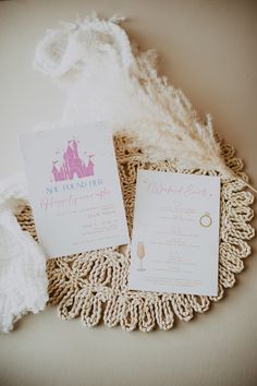 the wedding stationery is laid out on top of a doily with a white blanket