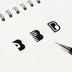 a pen is sitting on top of a spiral notebook with some black and white logos