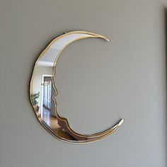 a mirror that is on the wall in front of a door with a reflection of a crescent