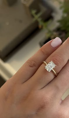 a woman's hand with a ring on it and a diamond in the middle