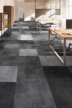 an empty office with desks and bookshelves on the walls, carpeted flooring