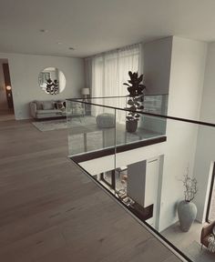 a living room filled with furniture and a glass railing