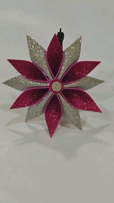 a red and silver christmas ornament on a white surface