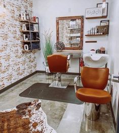 a hair salon with two chairs in front of a brick wall and shelves on either side