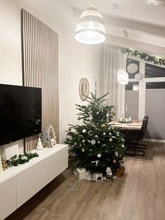 a living room with a christmas tree in the center and other decorations on the wall