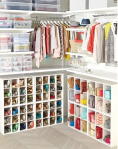 an open closet with lots of clothes and shoes on the shelves in front of it