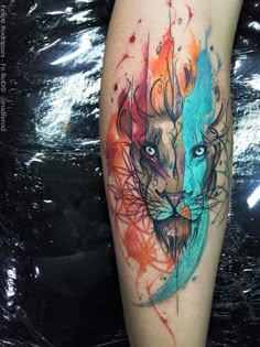 a colorful tattoo on the leg of a person with a lion's face painted on it