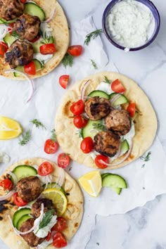 three pita breads topped with meat and veggies