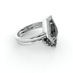 an engagement ring with black and white diamonds on it's sides, set in 18k white gold