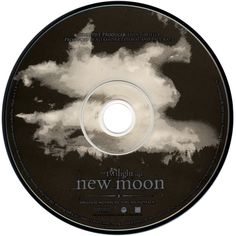 a cd disc with the words new moon on it and clouds in the sky above