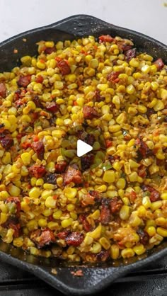 a skillet filled with corn on top of a stove