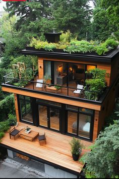 an aerial view of a house with plants growing on the roof and decking area