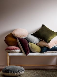 a bunch of pillows sitting on top of a bench