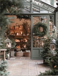 the inside of a greenhouse filled with lots of greenery and christmas wreaths on shelves