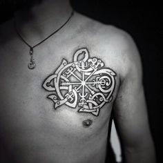 a man's chest with an intricate tattoo design on it