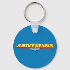 a blue round keychain with the word justice league on it's front