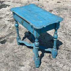 an old blue table sitting in the sand