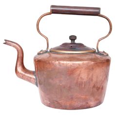 an old copper tea kettle with a wooden handle on it's side, isolated against a white background