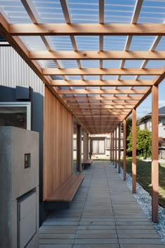 an outdoor walkway with wooden slatted roofing and benches on the side walk