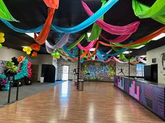 an empty dance floor with colorful streamers hanging from the ceiling