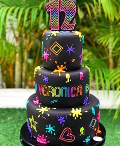 a three tiered cake decorated with neon colors