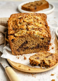 a loaf of banana nut bread on a wooden plate