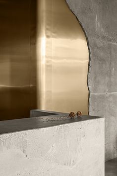 a vase sitting on top of a white counter next to a metal wall and clock