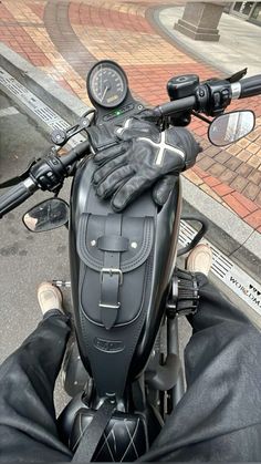 a close up of a motorcycle with gloves on it's handlebars and dashboard