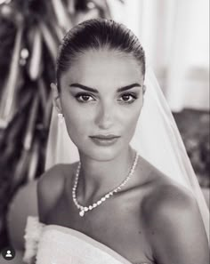 black and white photograph of a woman wearing a bridal gown with pearls on her necklace