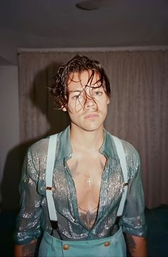 a young man with wet hair and suspenders