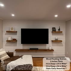 a living room with white brick walls and wooden floating shelves on the wall, along with a large flat screen tv