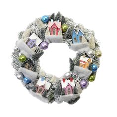 a christmas wreath with houses and ornaments hanging from it's sides on a white background