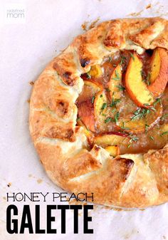 a close up of a pizza on a piece of paper with the words honey peach galaette