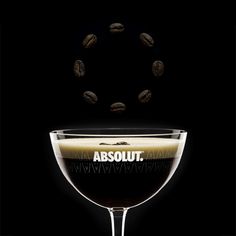 a glass filled with coffee beans and the words absolut