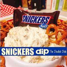 there is a bowl of dip and pretzels on the plate