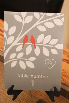 a table number holder with two birds on it