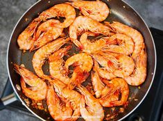 cooked shrimp and scallops in a frying pan with garnishes