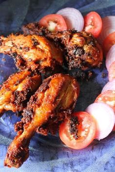 chicken wings with tomatoes and onions on a blue plate