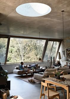 a living room filled with lots of furniture next to a large window covered in sunlight