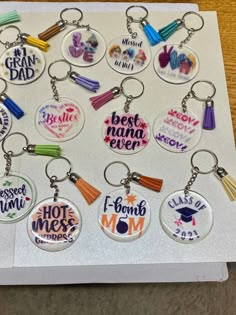 a bunch of key chains that have different designs on them, and the words best mama ever