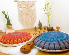 two decorative pillows on a table next to a plant