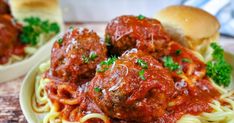 spaghetti and meatballs on a plate with bread rolls